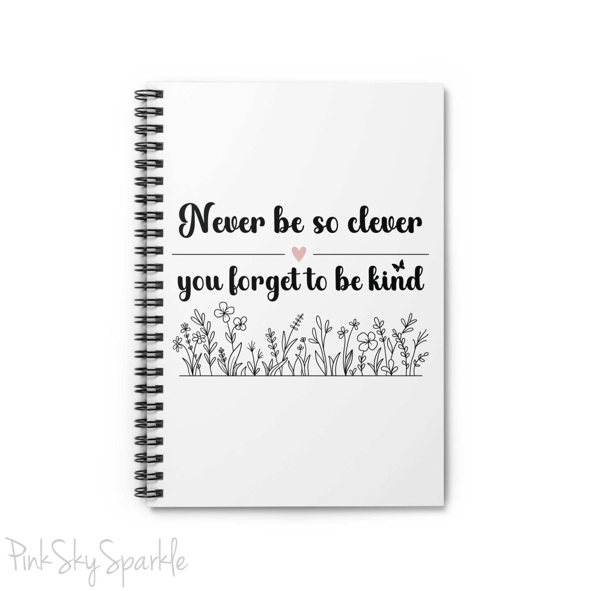 Spiral notebook with the quote "Never be so clever you forget to be kind" and flowers on it.
