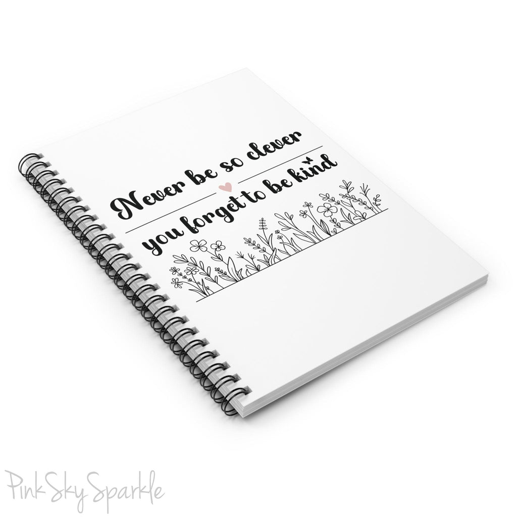 Spiral notebook with the quote "Never be so clever you forget to be kind" and flowers on it.