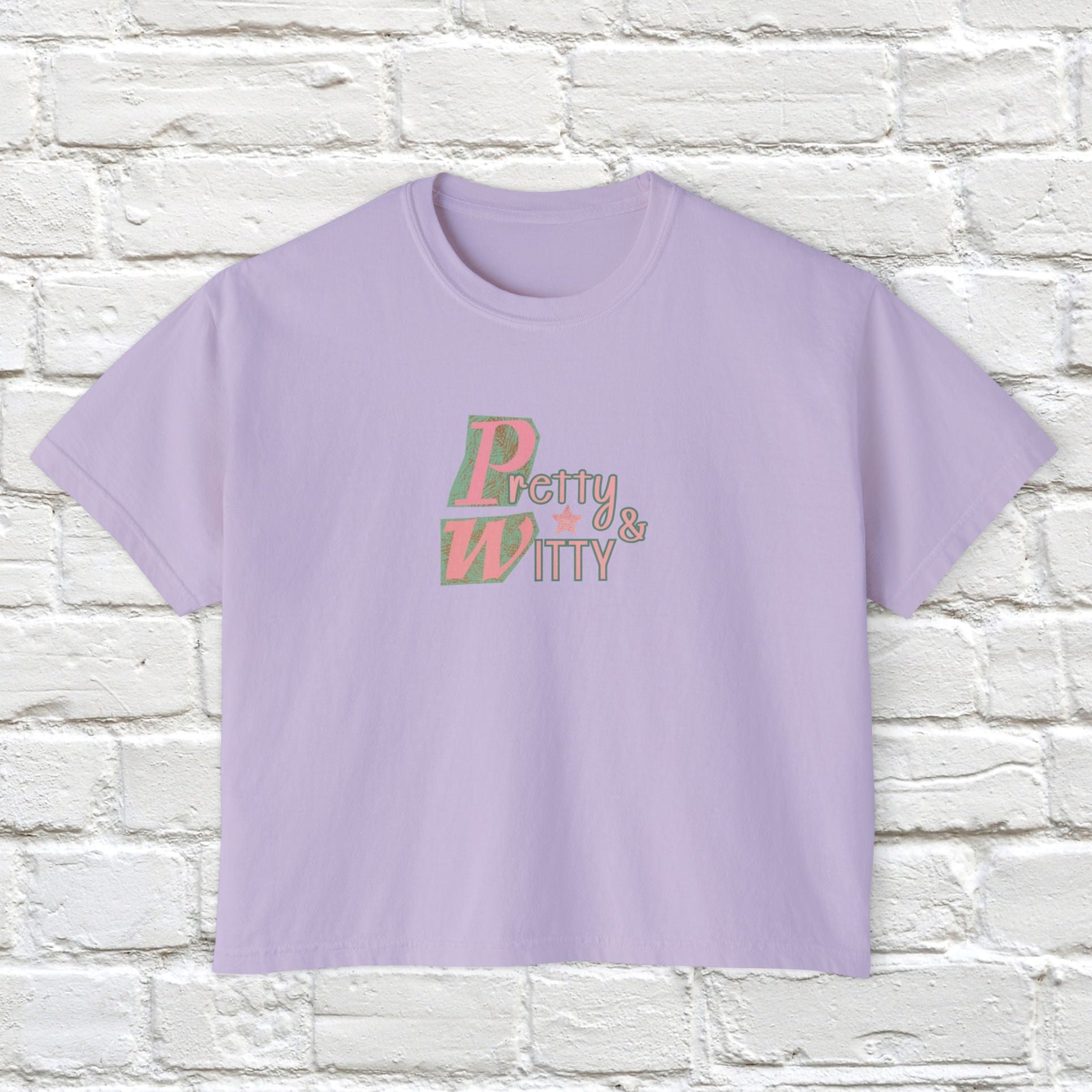 Lavender t-shirt with 'Pretty & Witty' text on a white brick wall background