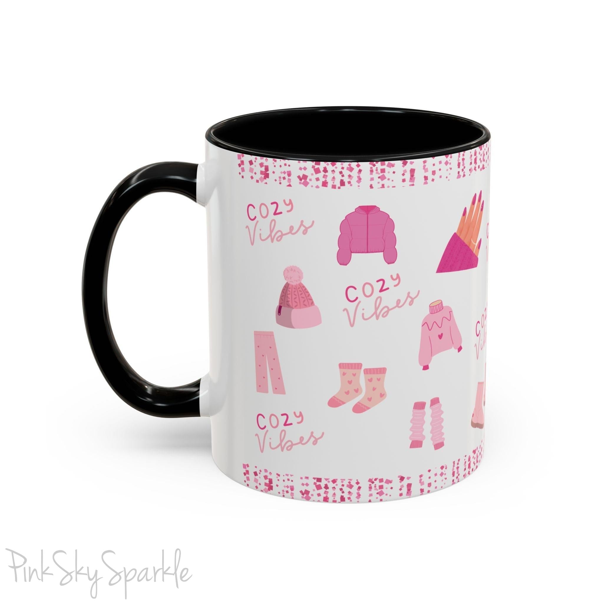 Pink Cozy Vibes Mug - Perfect for coffee, tea, or hot cocoa lovers! This ceramic mug features 'cozy vibes' in a pink font, surrounded by cute illustrations of pink cozy items such as slippers, mittens, blankets and candles. Ideal for creating a warm, cozy atmosphere, this pink-handled mug (also available in light blue, black and navy) makes a great gift for anyone who loves comfort, style and the color pink.