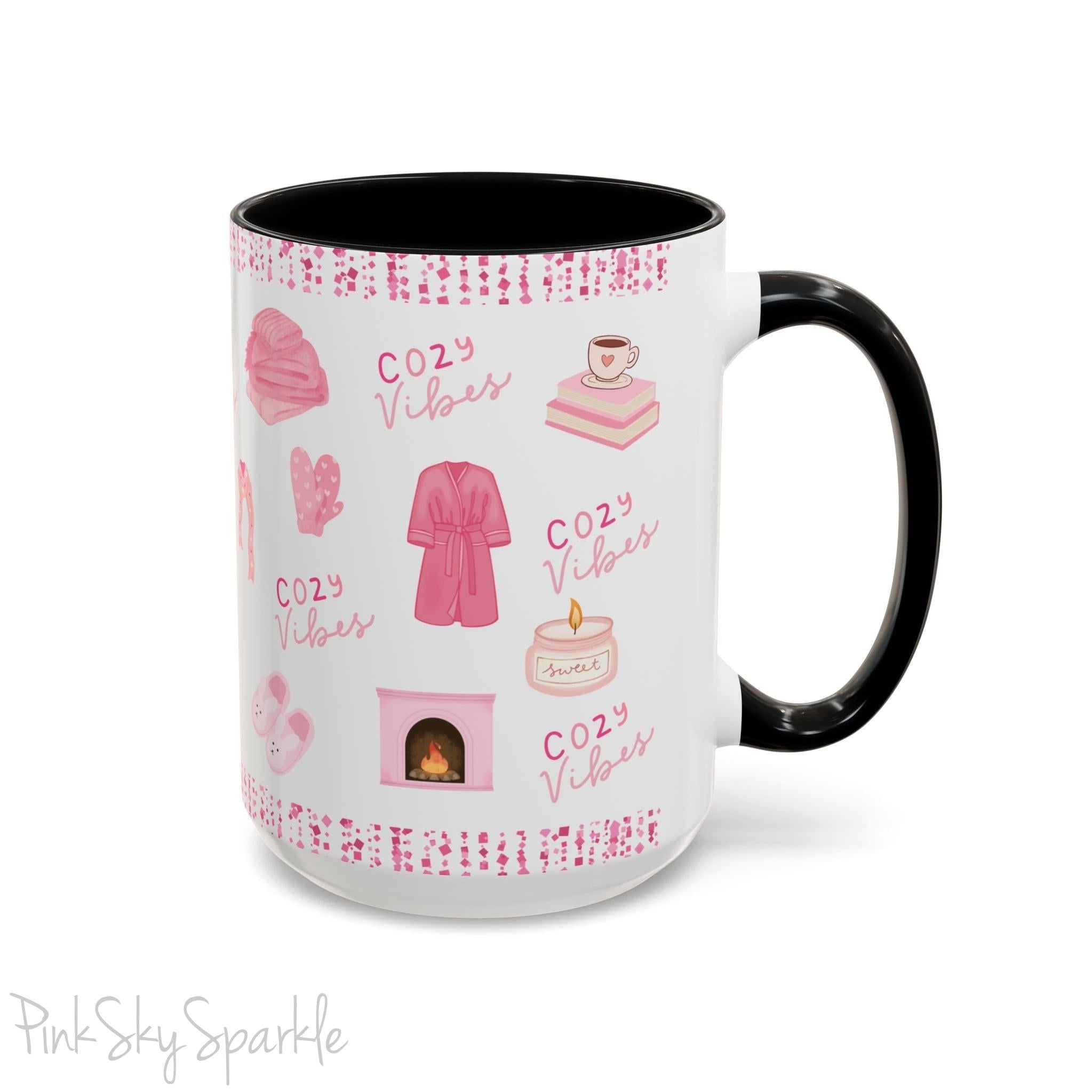 Pink Cozy Vibes Mug - Perfect for coffee, tea, or hot cocoa lovers! This ceramic mug features 'cozy vibes' in a pink font, surrounded by cute illustrations of pink cozy items such as slippers, mittens, blankets and candles. Ideal for creating a warm, cozy atmosphere, this pink-handled mug (also available in light blue, black and navy) makes a great gift for anyone who loves comfort, style and the color pink.