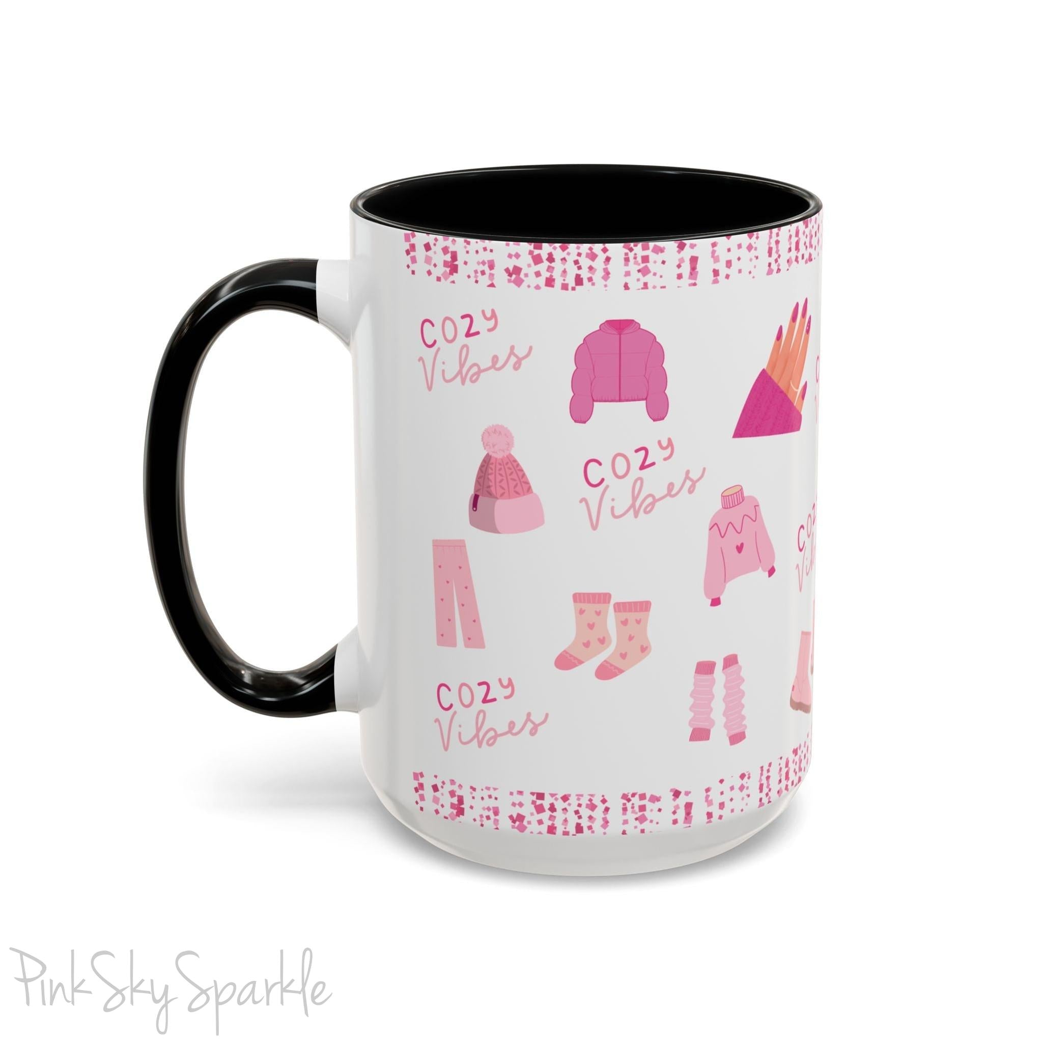 Pink Cozy Vibes Mug - Perfect for coffee, tea, or hot cocoa lovers! This ceramic mug features 'cozy vibes' in a pink font, surrounded by cute illustrations of pink cozy items such as slippers, mittens, blankets and candles. Ideal for creating a warm, cozy atmosphere, this pink-handled mug (also available in light blue, black and navy) makes a great gift for anyone who loves comfort, style and the color pink.