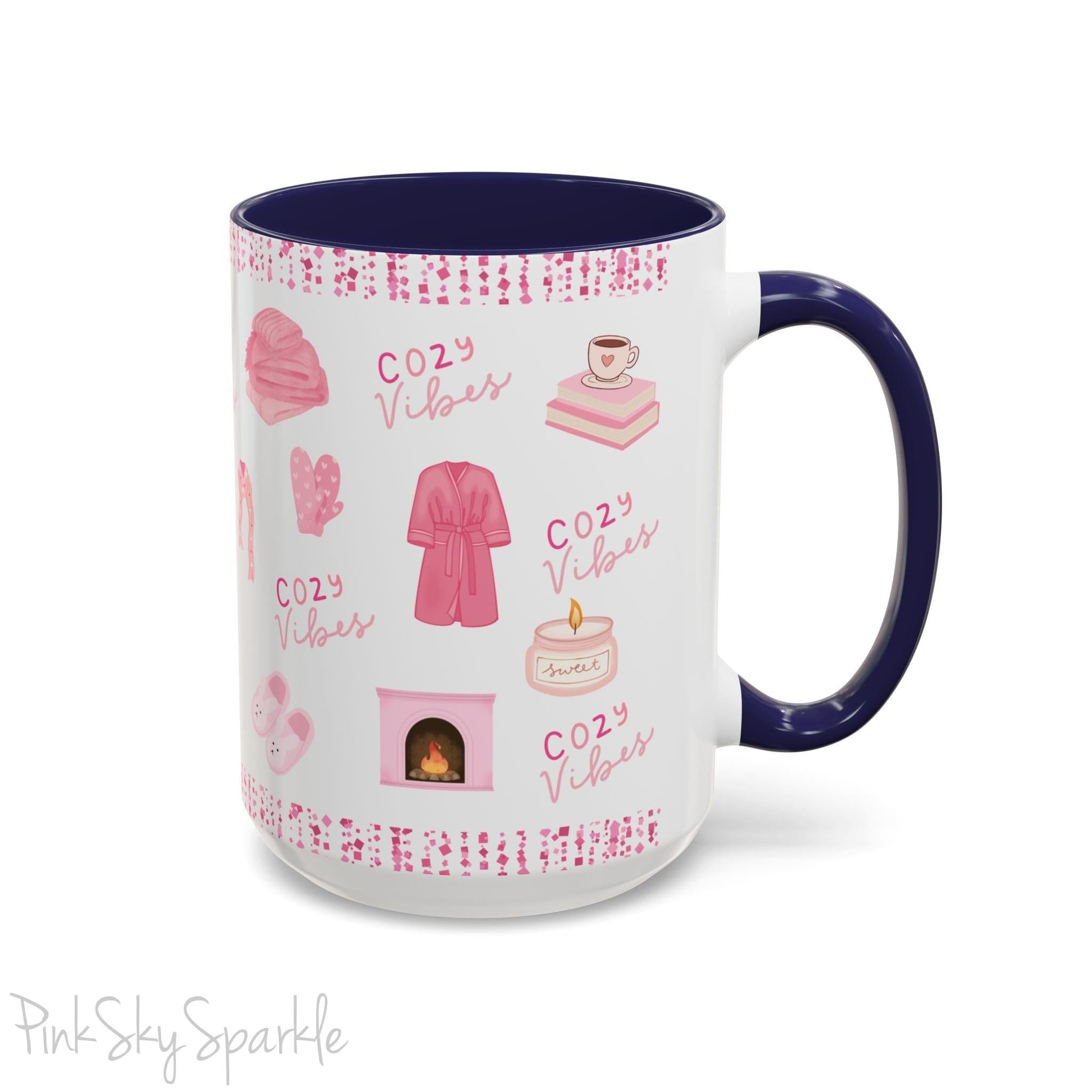 Pink Cozy Vibes Mug - Perfect for coffee, tea, or hot cocoa lovers! This ceramic mug features 'cozy vibes' in a pink font, surrounded by cute illustrations of pink cozy items such as slippers, mittens, blankets and candles. Ideal for creating a warm, cozy atmosphere, this pink-handled mug (also available in light blue, black and navy) makes a great gift for anyone who loves comfort, style and the color pink.