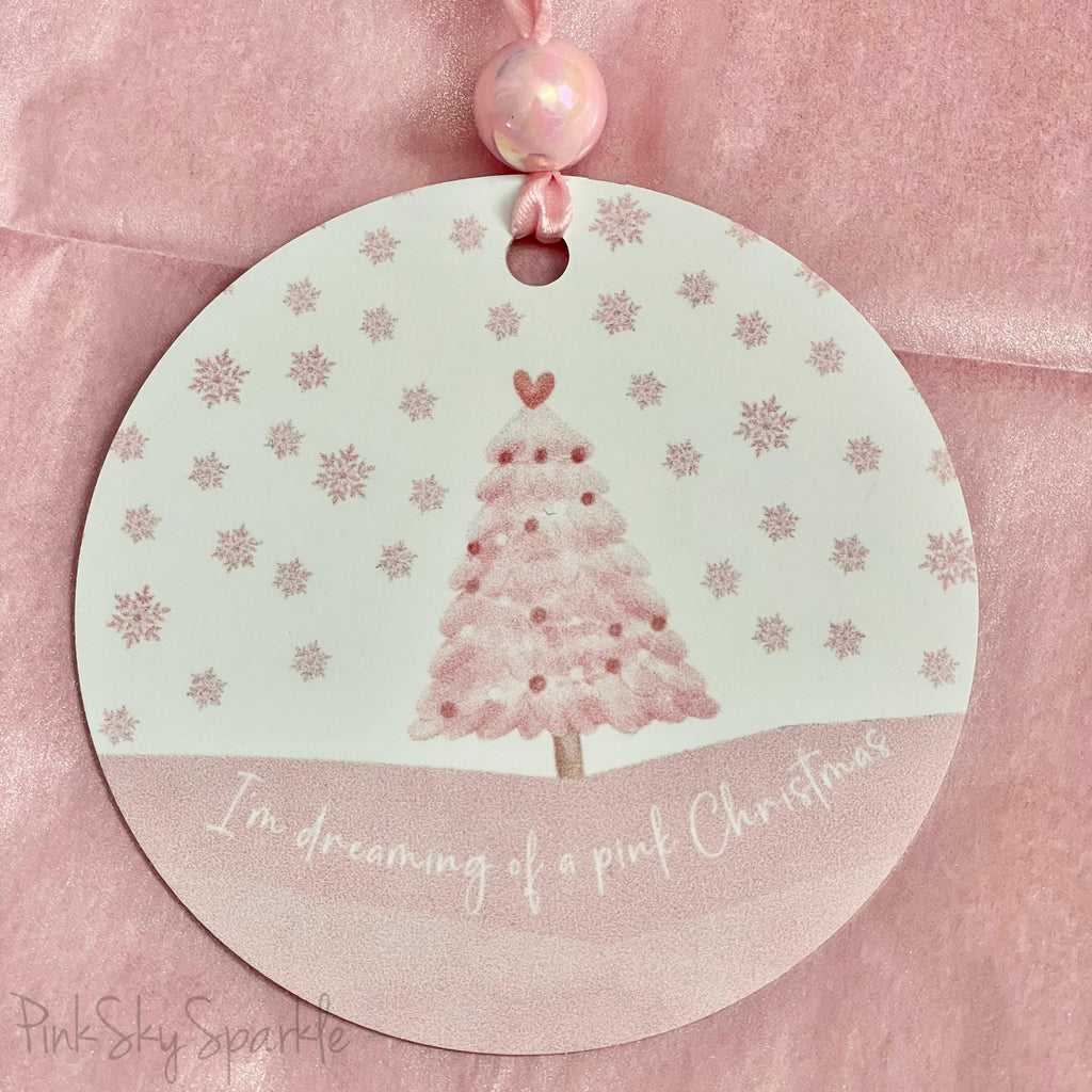 A pink Christmas tree ornament with soft pastel tones and elegant design, featuring the phrase "I'm Dreaming of a Pink Christmas." Perfect for adding a whimsical touch to holiday decor.