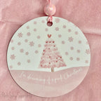 A pink Christmas tree ornament with soft pastel tones and elegant design, featuring the phrase "I'm Dreaming of a Pink Christmas." Perfect for adding a whimsical touch to holiday decor.