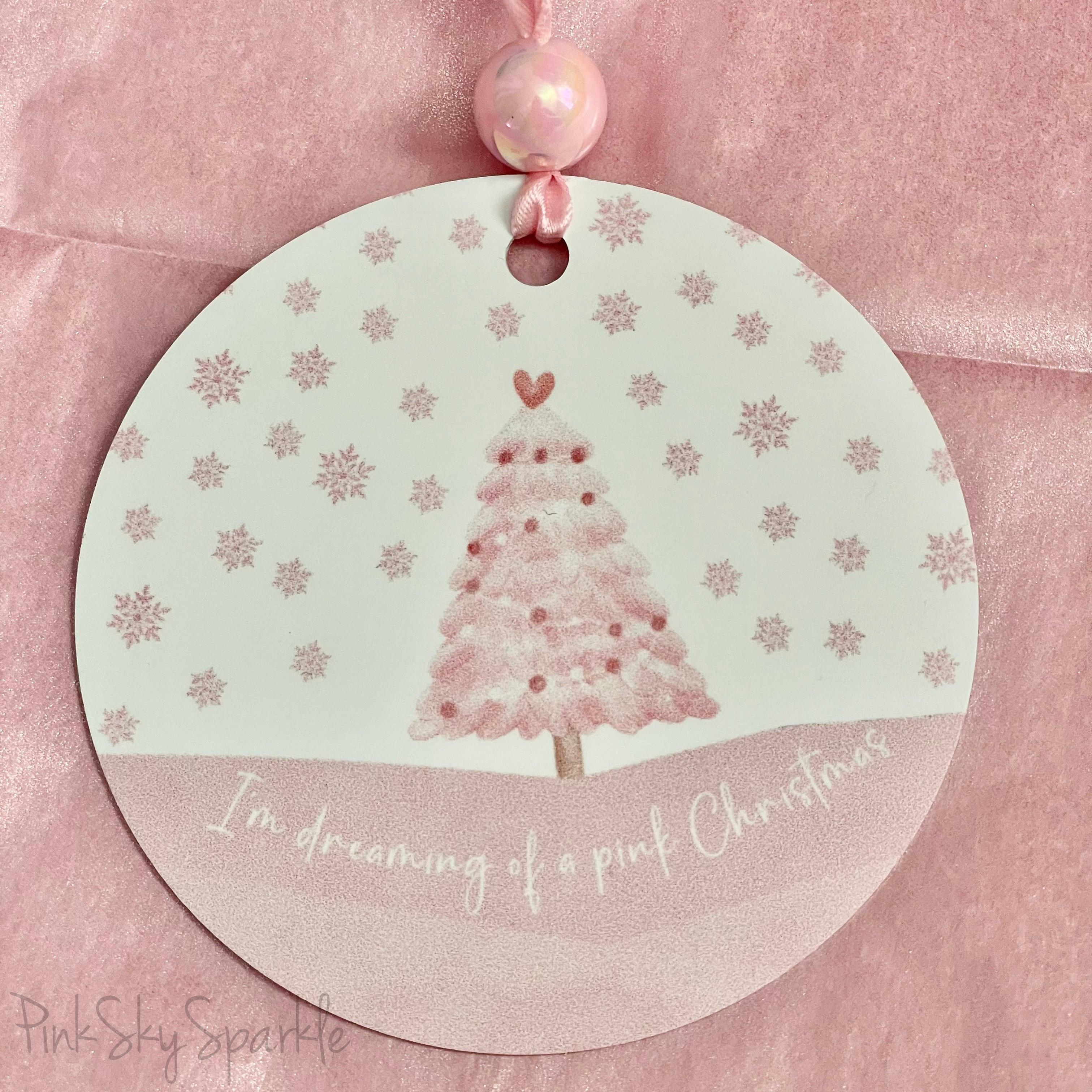 A pink Christmas tree ornament with soft pastel tones and elegant design, featuring the phrase "I'm Dreaming of a Pink Christmas." Perfect for adding a whimsical touch to holiday decor.