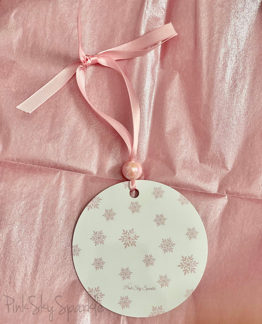 A pink Christmas tree ornament with soft pastel tones and elegant design, featuring the phrase "I'm Dreaming of a Pink Christmas." Perfect for adding a whimsical touch to holiday decor.
