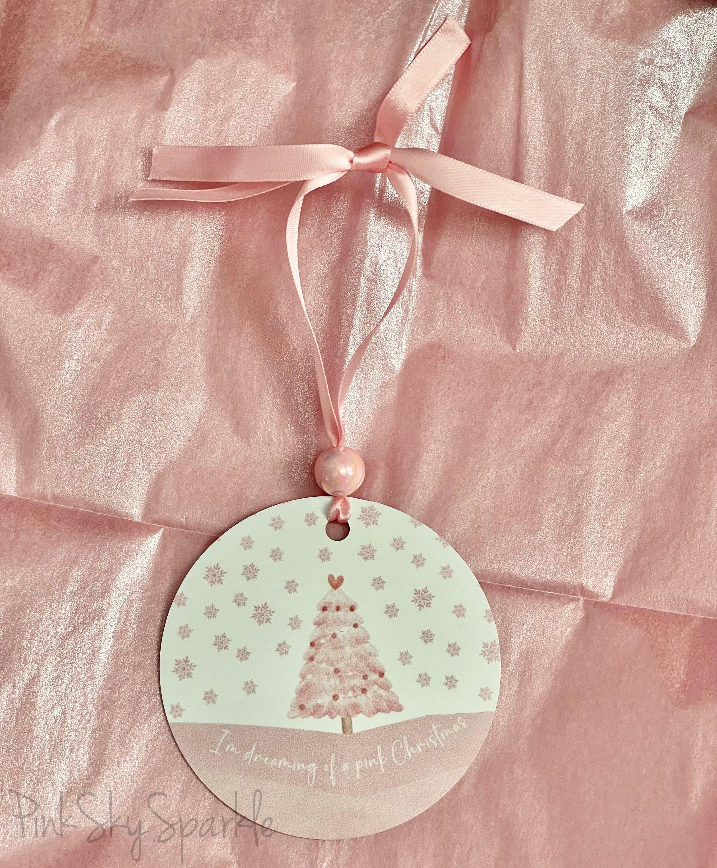 A pink Christmas tree ornament with soft pastel tones and elegant design, featuring the phrase "I'm Dreaming of a Pink Christmas." Perfect for adding a whimsical touch to holiday decor.