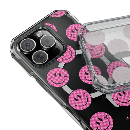 Clear magnetic phone case featuring pink checkered smiley faces on a transparent background, designed for MagSafe® compatibility with air-cushioned bumper corners.