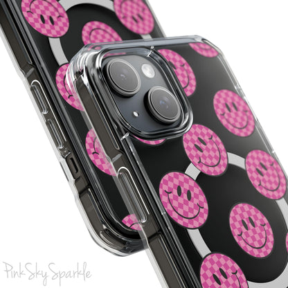Clear magnetic phone case featuring pink checkered smiley faces on a transparent background, designed for MagSafe® compatibility with air-cushioned bumper corners.