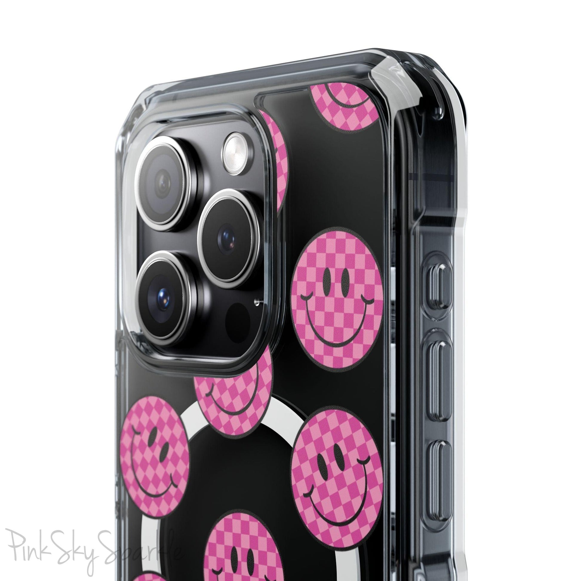 Clear magnetic phone case featuring pink checkered smiley faces on a transparent background, designed for MagSafe® compatibility with air-cushioned bumper corners.