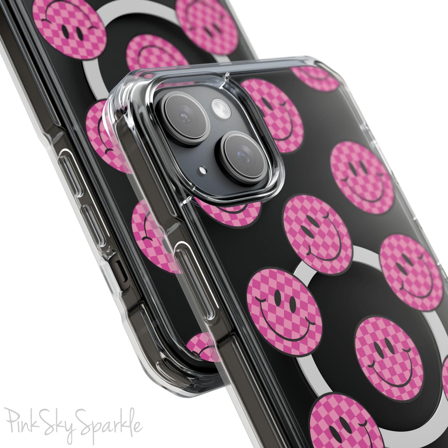 Clear magnetic phone case featuring pink checkered smiley faces on a transparent background, designed for MagSafe® compatibility with air-cushioned bumper corners.