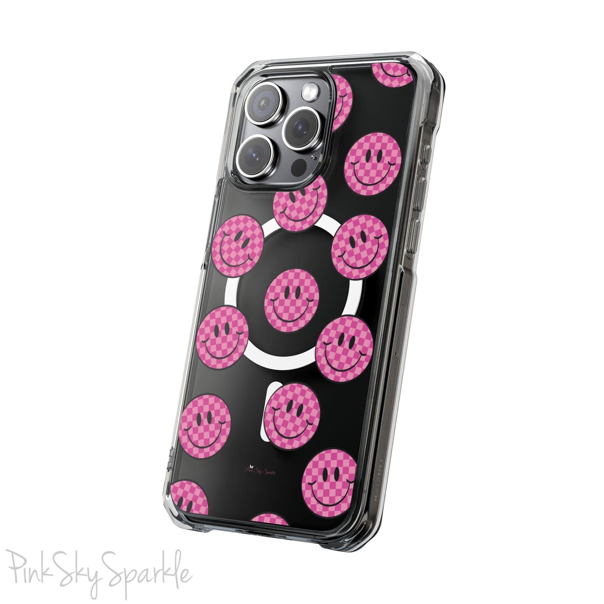 Clear magnetic phone case featuring pink checkered smiley faces on a transparent background, designed for MagSafe® compatibility with air-cushioned bumper corners.