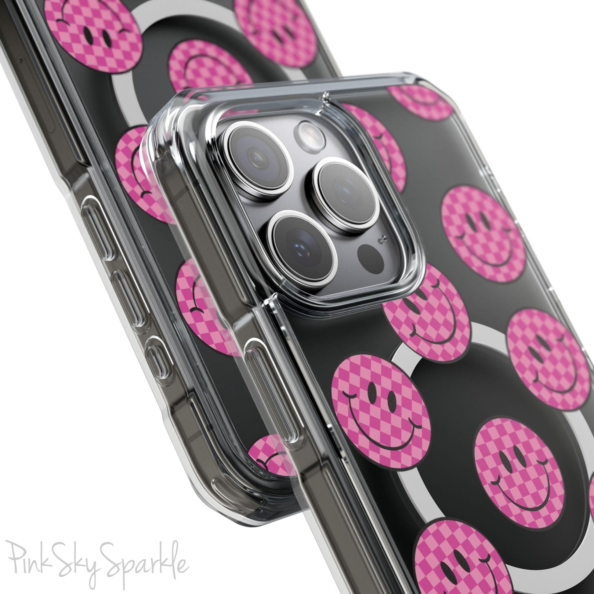 Clear magnetic phone case featuring pink checkered smiley faces on a transparent background, designed for MagSafe® compatibility with air-cushioned bumper corners.