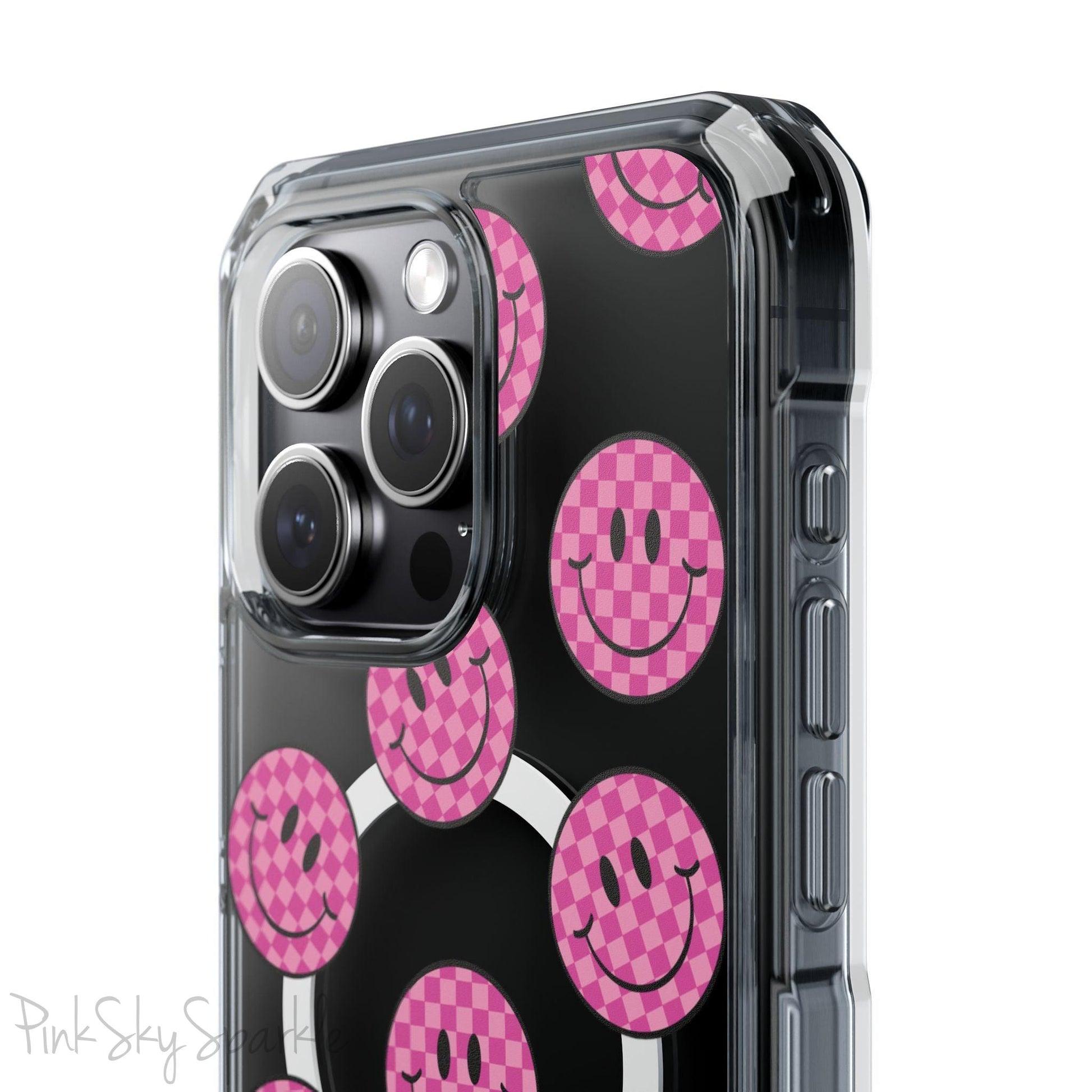 Clear magnetic phone case featuring pink checkered smiley faces on a transparent background, designed for MagSafe® compatibility with air-cushioned bumper corners.