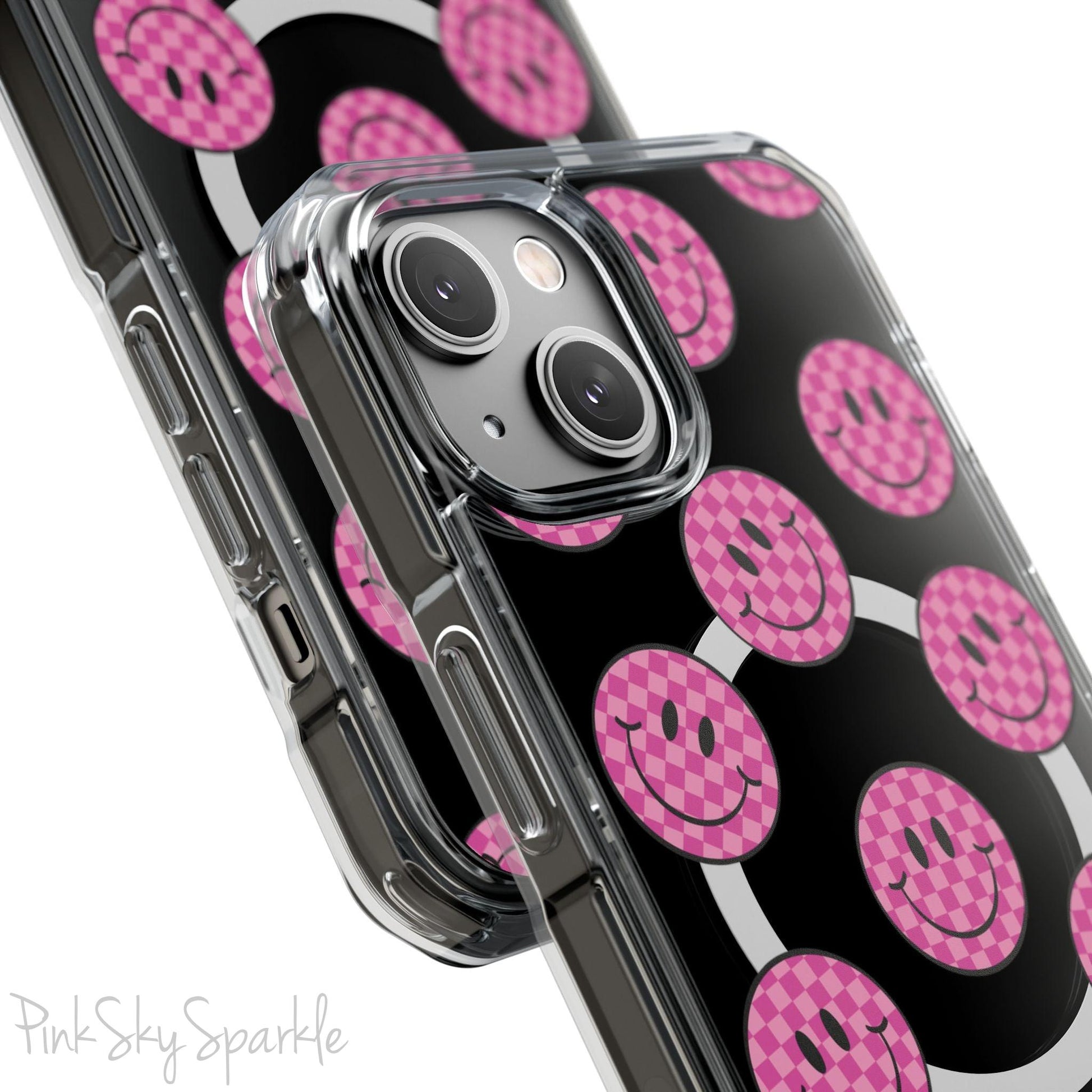 Clear magnetic phone case featuring pink checkered smiley faces on a transparent background, designed for MagSafe® compatibility with air-cushioned bumper corners.