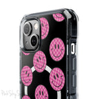 Clear magnetic phone case featuring pink checkered smiley faces on a transparent background, designed for MagSafe® compatibility with air-cushioned bumper corners.