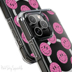 Clear magnetic phone case featuring pink checkered smiley faces on a transparent background, designed for MagSafe® compatibility with air-cushioned bumper corners.