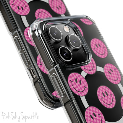 Clear magnetic phone case featuring pink checkered smiley faces on a transparent background, designed for MagSafe® compatibility with air-cushioned bumper corners.