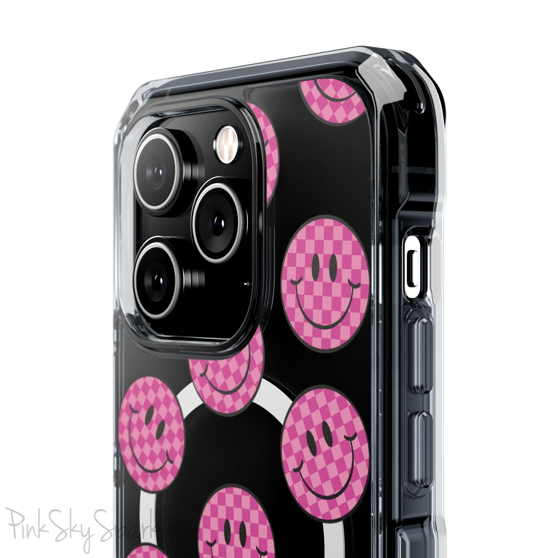 Clear magnetic phone case featuring pink checkered smiley faces on a transparent background, designed for MagSafe® compatibility with air-cushioned bumper corners.