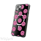 Clear magnetic phone case featuring pink checkered smiley faces on a transparent background, designed for MagSafe® compatibility with air-cushioned bumper corners.