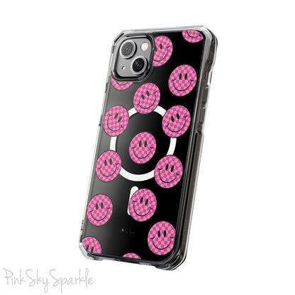 Clear magnetic phone case featuring pink checkered smiley faces on a transparent background, designed for MagSafe® compatibility with air-cushioned bumper corners.