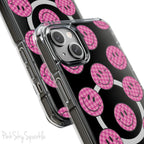 Clear magnetic phone case featuring pink checkered smiley faces on a transparent background, designed for MagSafe® compatibility with air-cushioned bumper corners.