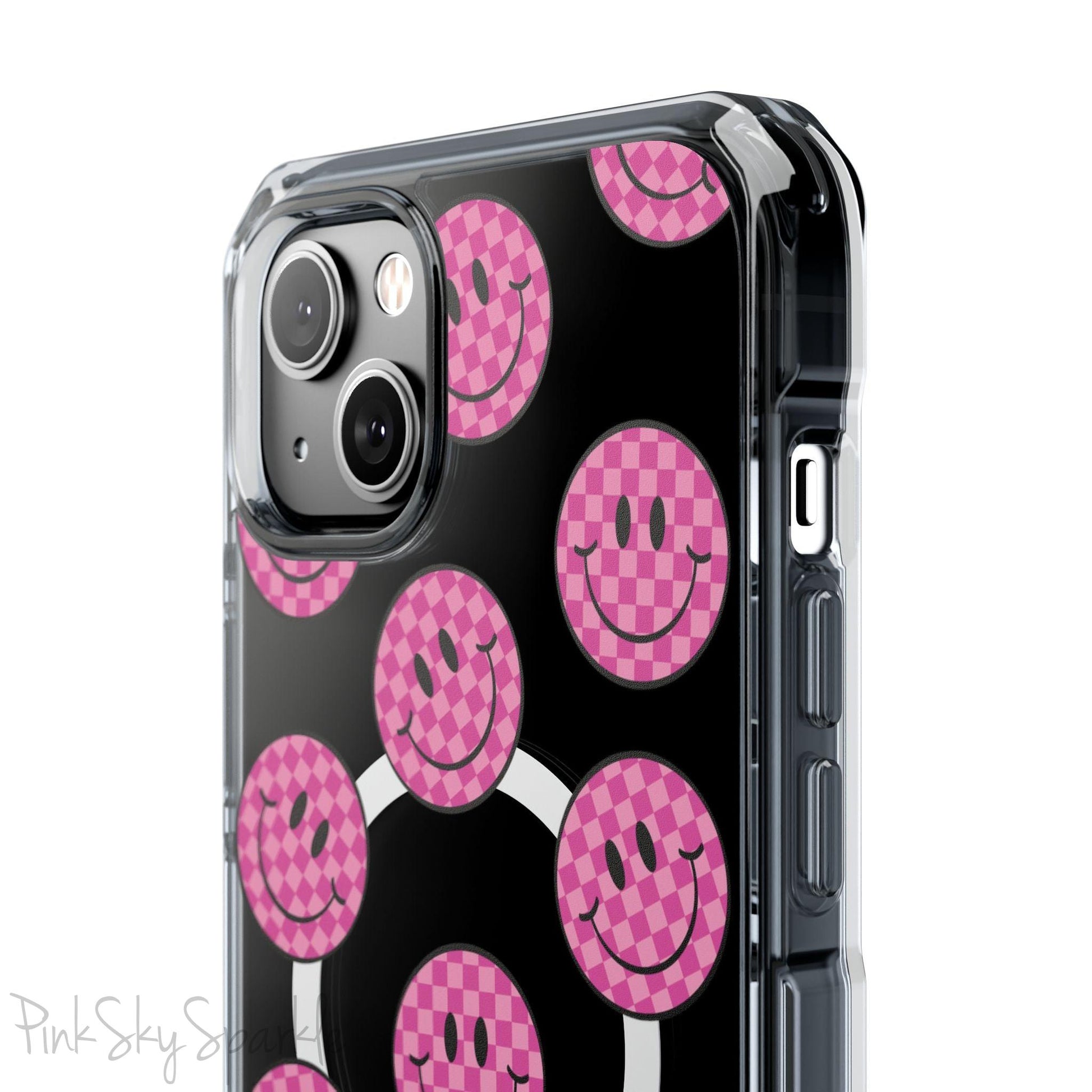 Clear magnetic phone case featuring pink checkered smiley faces on a transparent background, designed for MagSafe® compatibility with air-cushioned bumper corners.