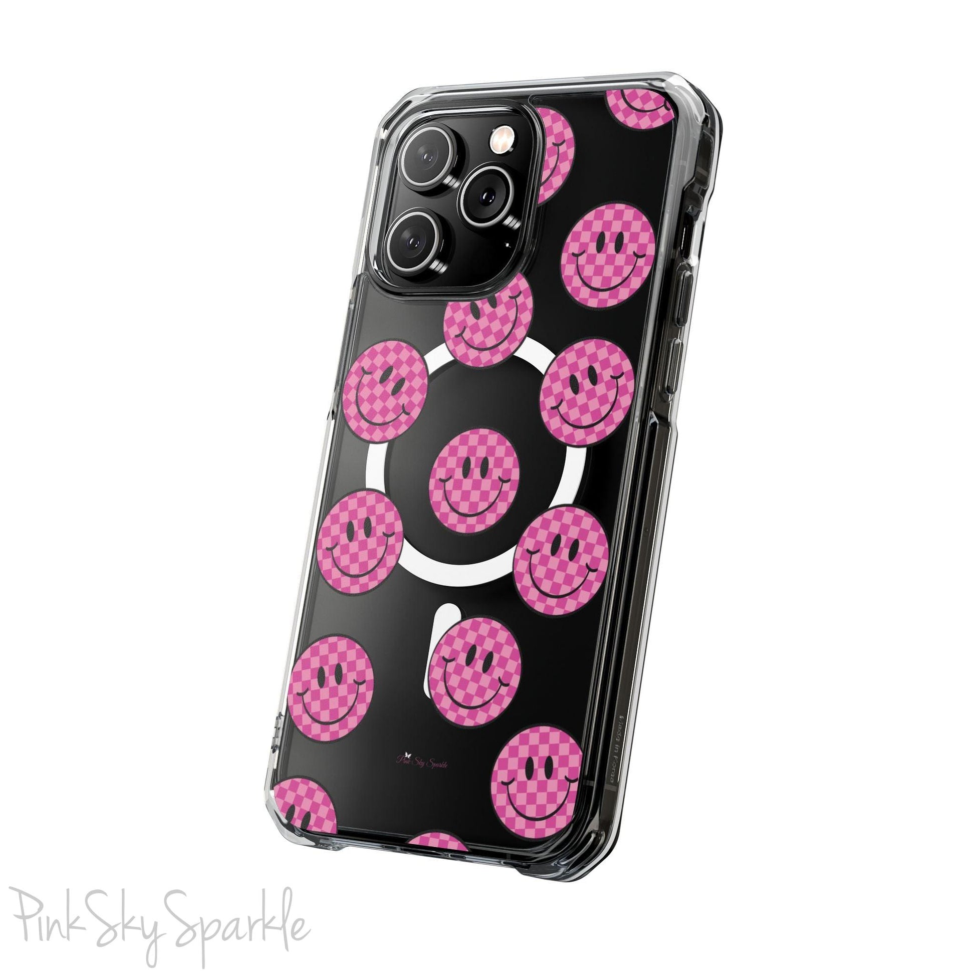 Clear magnetic phone case featuring pink checkered smiley faces on a transparent background, designed for MagSafe® compatibility with air-cushioned bumper corners.