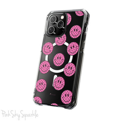 Clear magnetic phone case featuring pink checkered smiley faces on a transparent background, designed for MagSafe® compatibility with air-cushioned bumper corners.