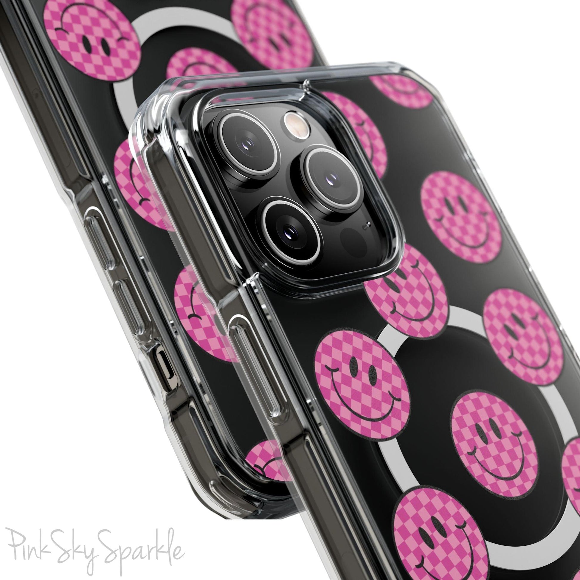 Clear magnetic phone case featuring pink checkered smiley faces on a transparent background, designed for MagSafe® compatibility with air-cushioned bumper corners.