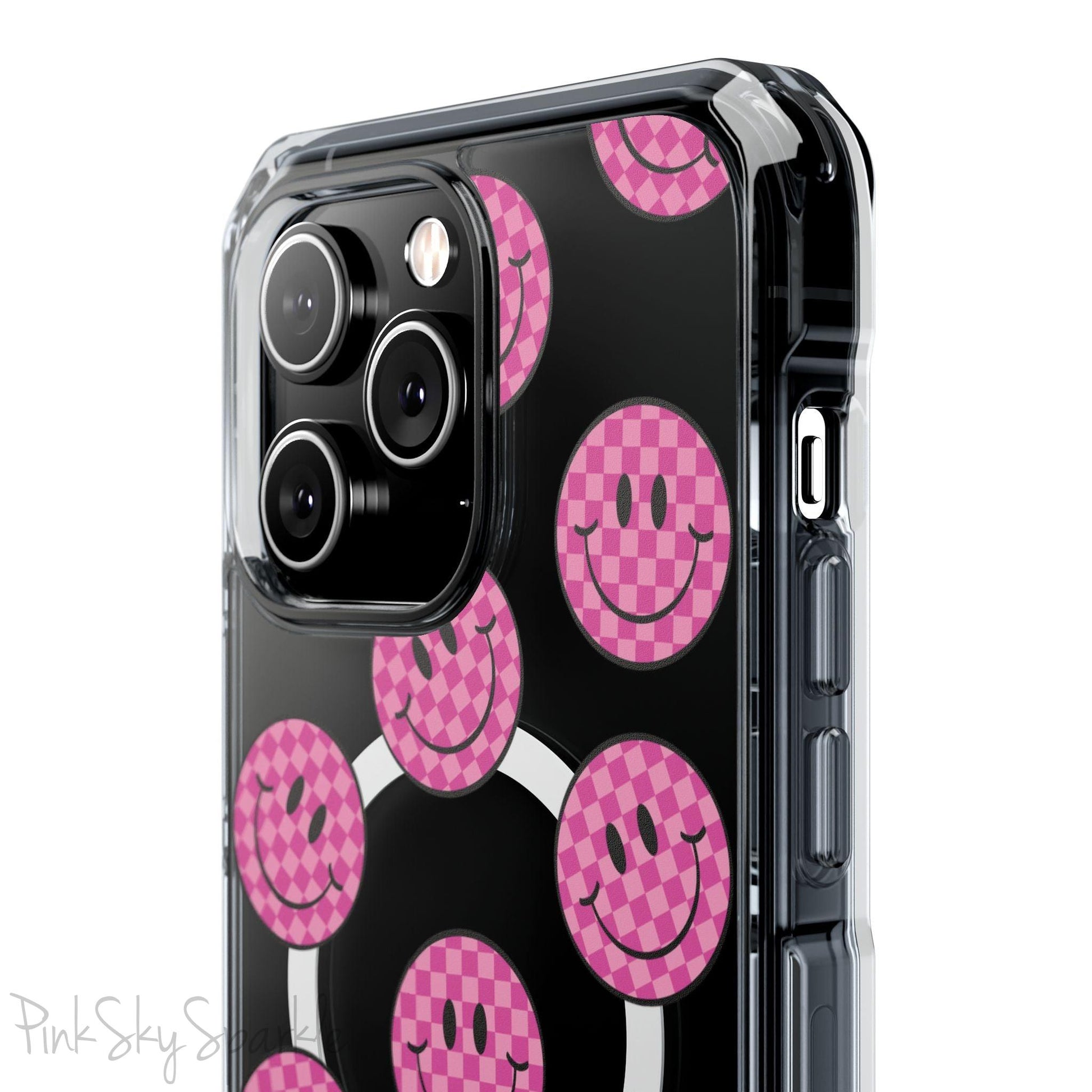 Clear magnetic phone case featuring pink checkered smiley faces on a transparent background, designed for MagSafe® compatibility with air-cushioned bumper corners.