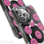 Clear magnetic phone case featuring pink checkered smiley faces on a transparent background, designed for MagSafe® compatibility with air-cushioned bumper corners.