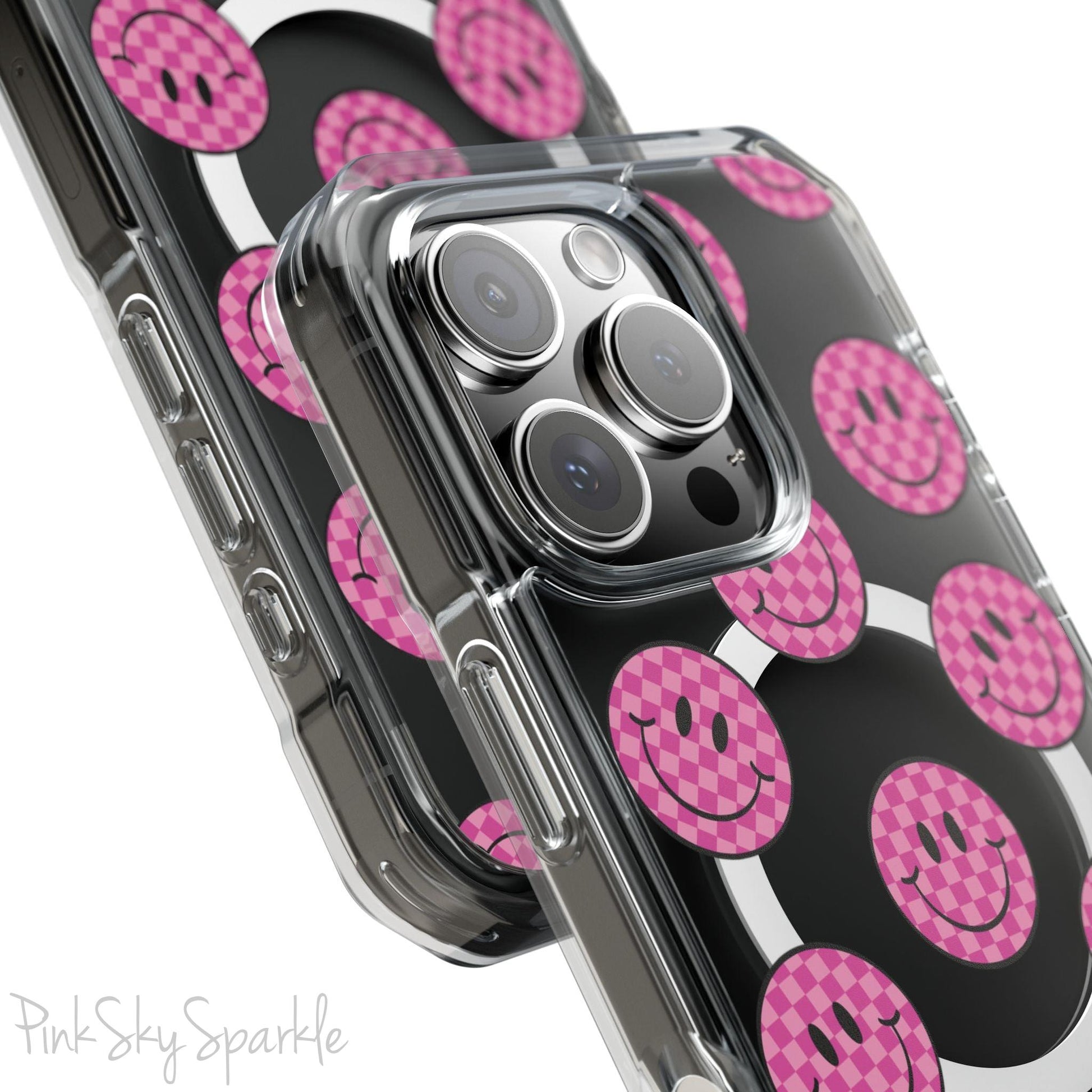 Clear magnetic phone case featuring pink checkered smiley faces on a transparent background, designed for MagSafe® compatibility with air-cushioned bumper corners.