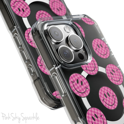 Clear magnetic phone case featuring pink checkered smiley faces on a transparent background, designed for MagSafe® compatibility with air-cushioned bumper corners.
