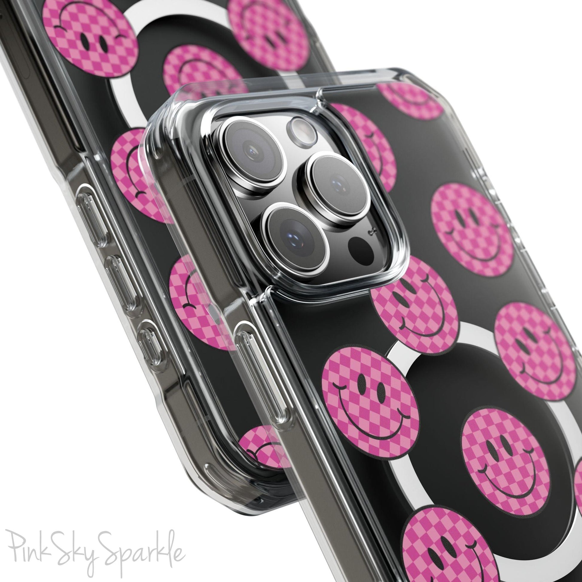 Clear magnetic phone case featuring pink checkered smiley faces on a transparent background, designed for MagSafe® compatibility with air-cushioned bumper corners.