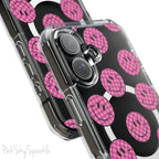 Clear magnetic phone case featuring pink checkered smiley faces on a transparent background, designed for MagSafe® compatibility with air-cushioned bumper corners.