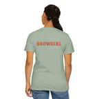 Person wearing a light green t-shirt with 'SHOWGIRL' printed on the back, standing against a white background.
