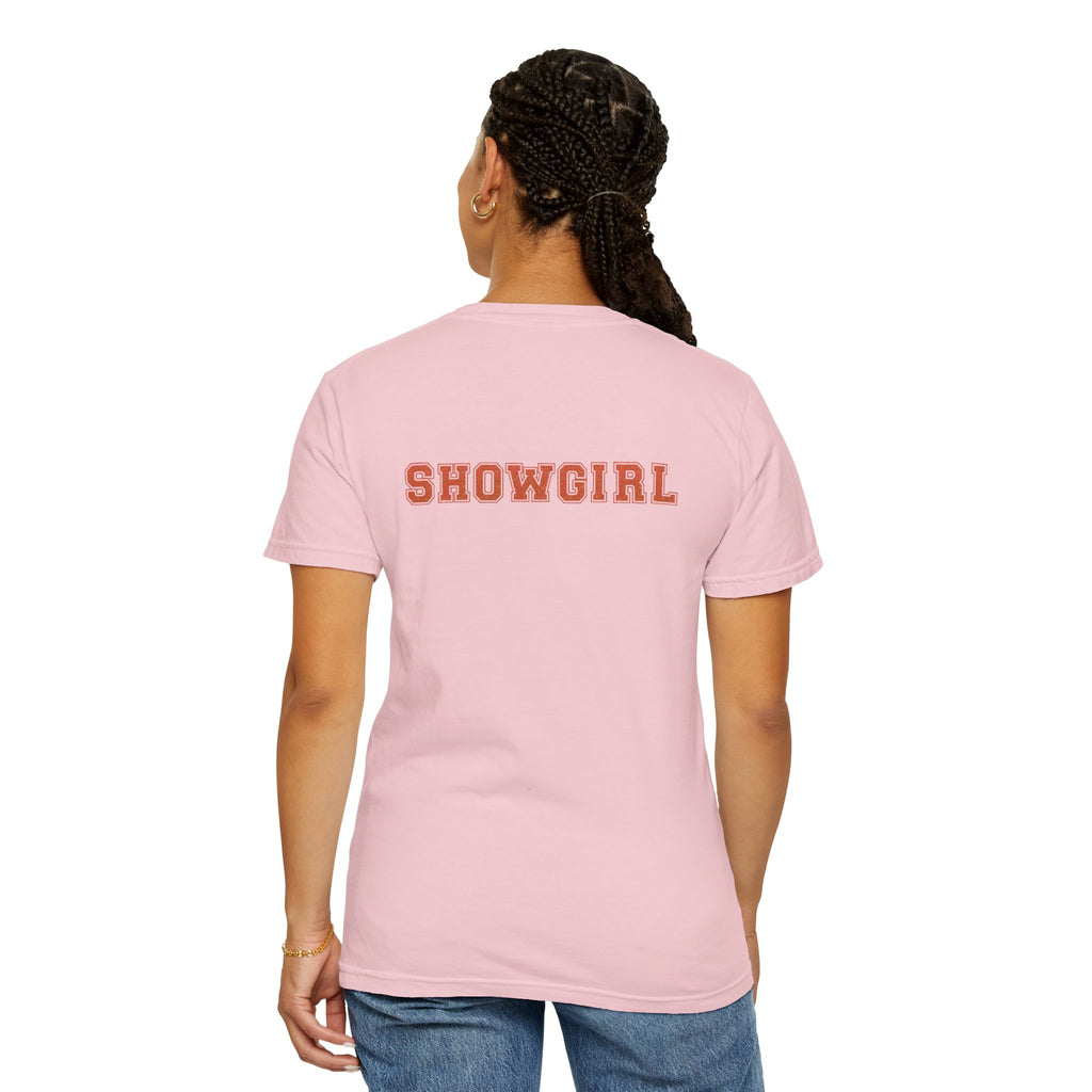 Person wearing a pink t-shirt with 'SHOWGIRL' text on the back, standing against a white background.