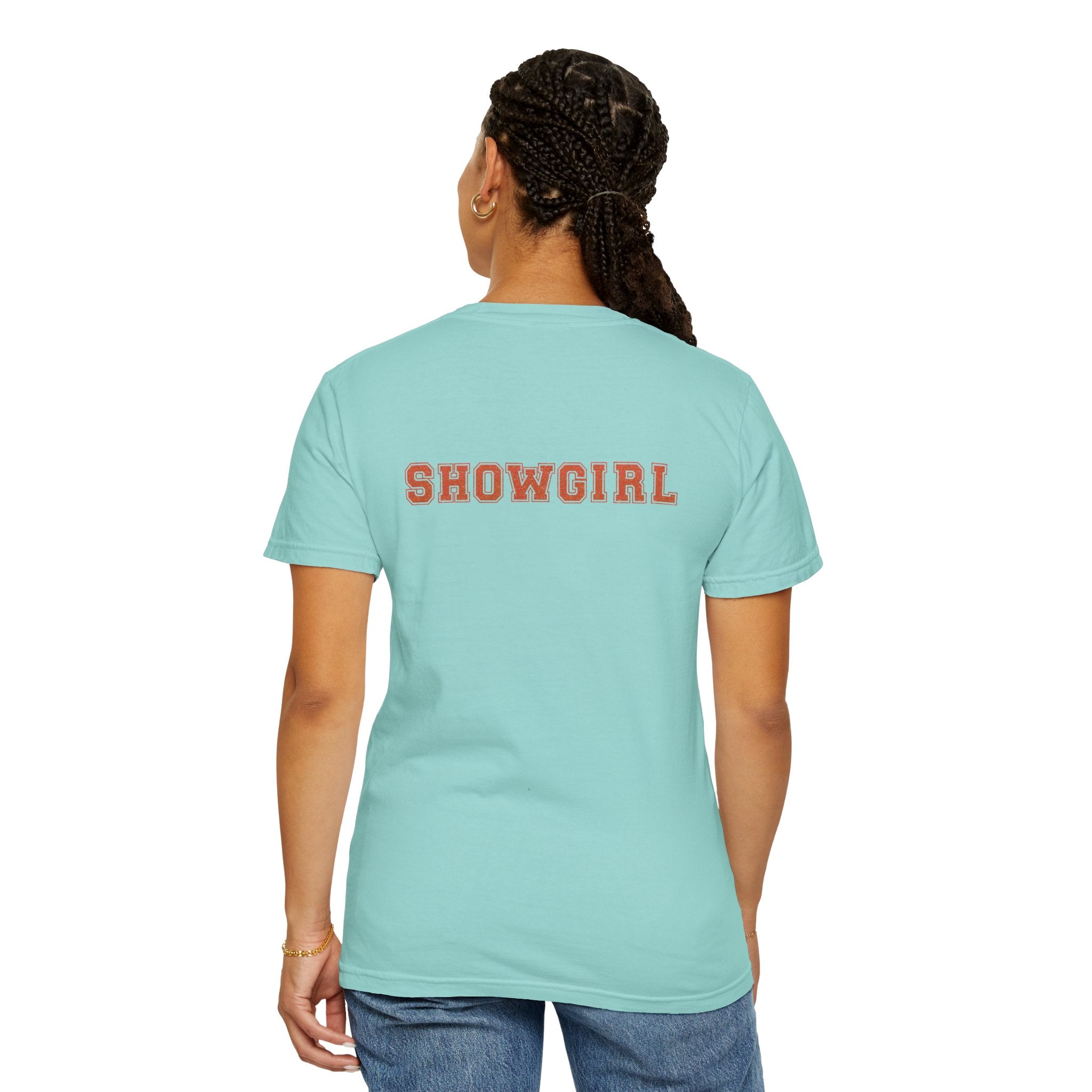 Person wearing a light blue t-shirt with 'SHOWGIRL' printed on the back, on a white background