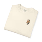 Folded cream-colored t-shirt with a showgirl graphic design on a white background