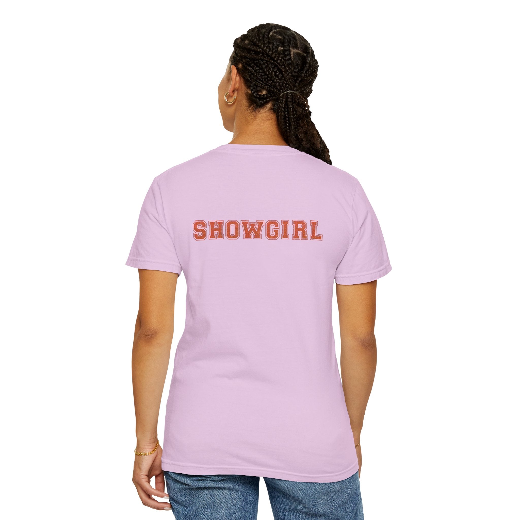 Person wearing a pink t-shirt with 'SHOWGIRL' text on the back, standing against a white background.