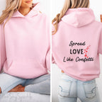 Cozy sweatshirt with the uplifting message “Spread Love Like Confetti” in bold, stylish font.