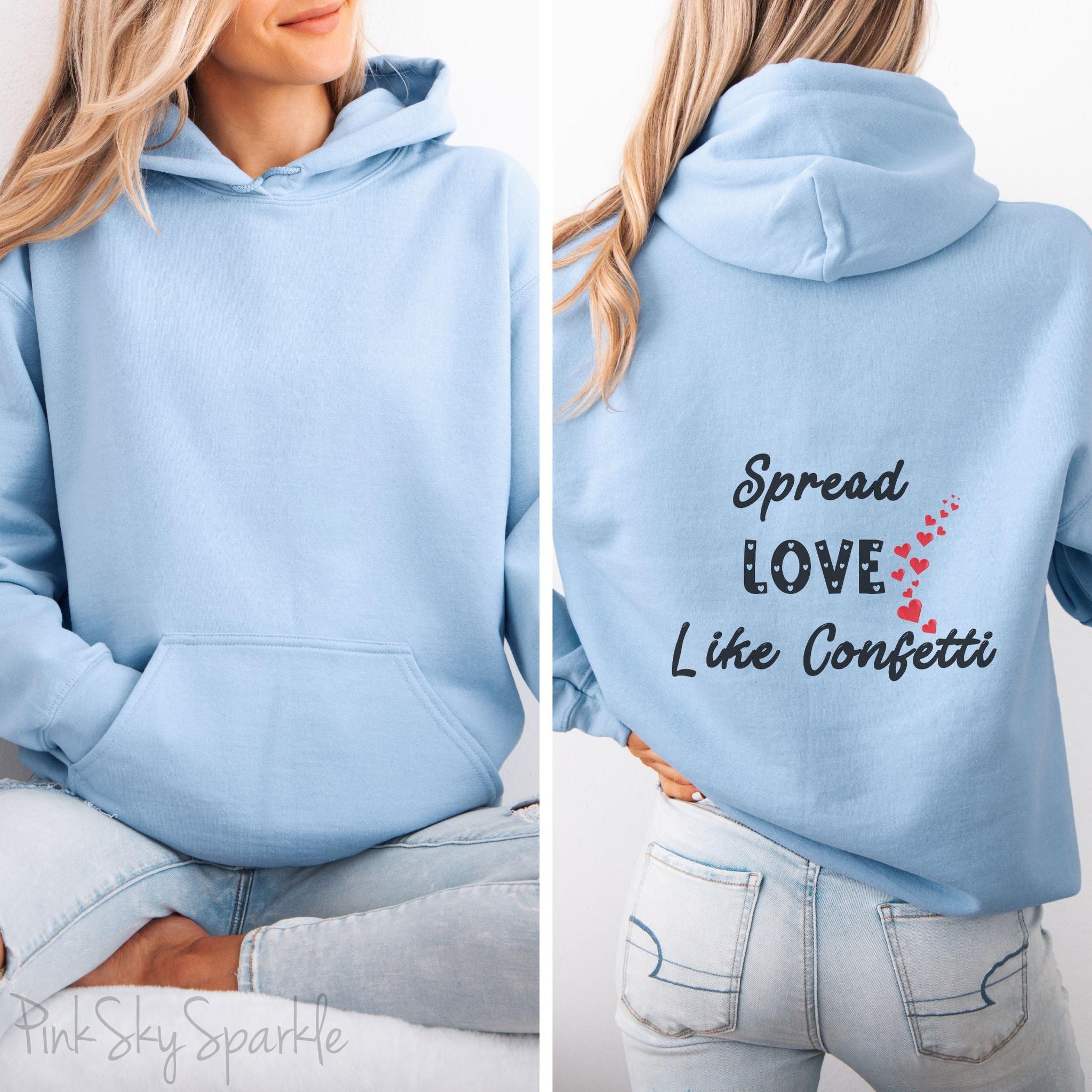 Cozy sweatshirt with the uplifting message “Spread Love Like Confetti” in bold, stylish font.