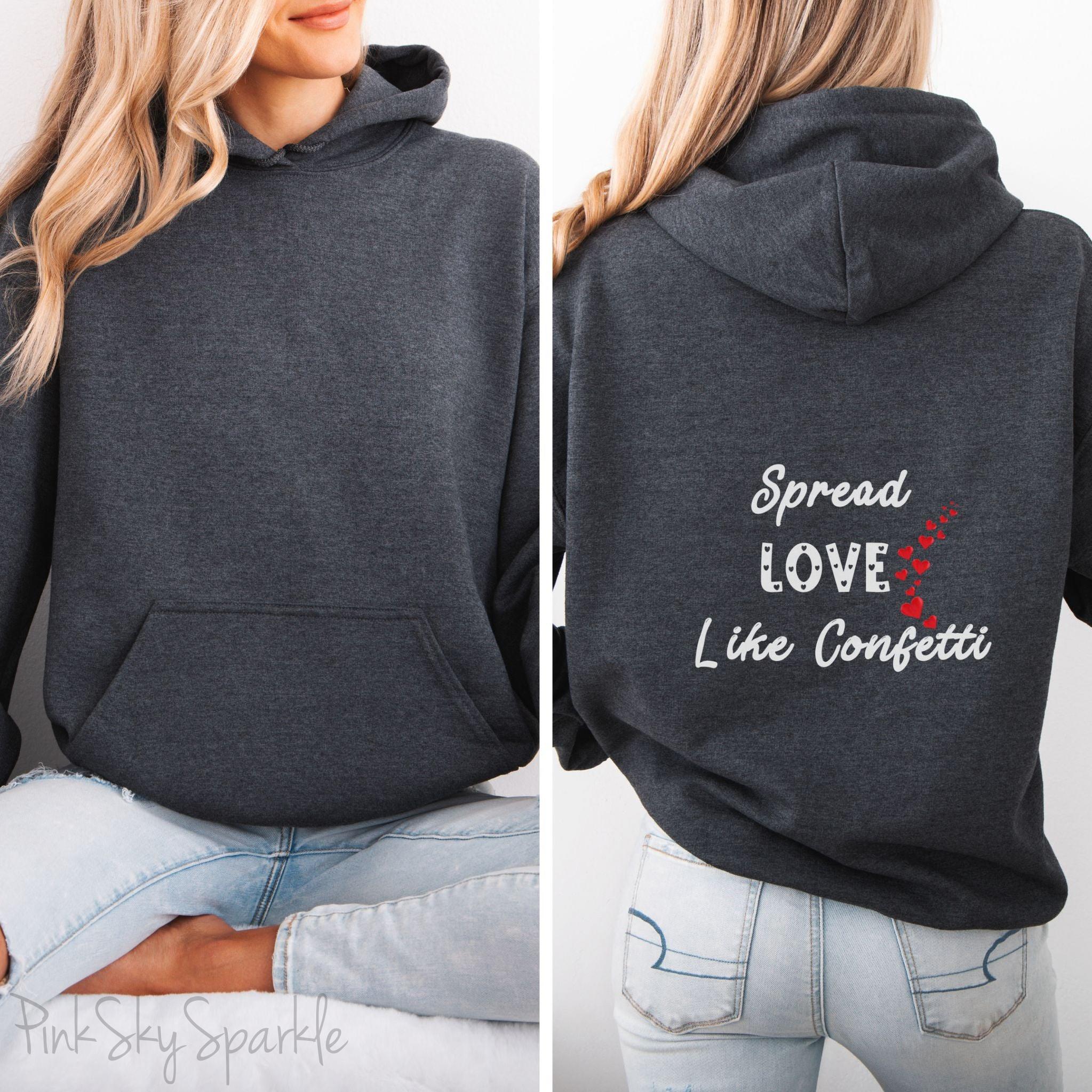 Cozy sweatshirt with the uplifting message “Spread Love Like Confetti” in bold, stylish font.