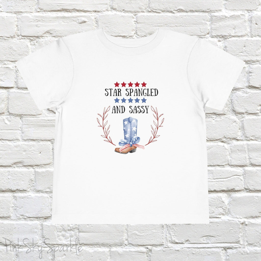 Dress your little one in patriotic style with our adorable toddler t-shirt, perfect for the 4th of July! This charming tee features the playful phrase "Star Spangled and Sassy" alongside a cute graphic of a red, white, and blue cowgirl boot adorned with a bow.