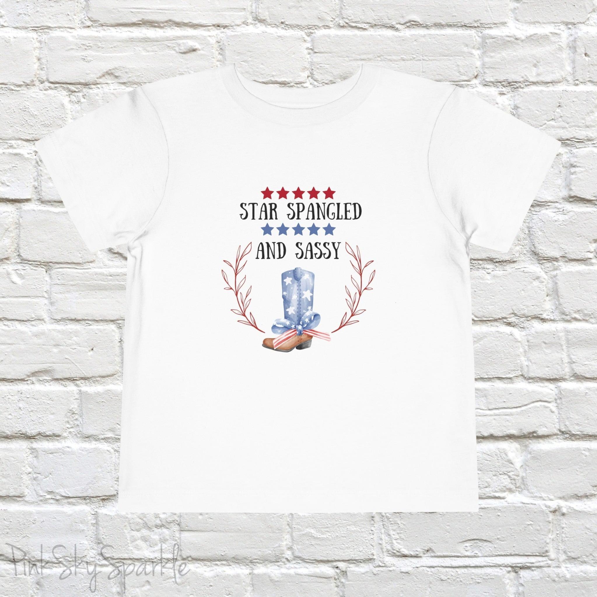 Dress your little one in patriotic style with our adorable toddler t-shirt, perfect for the 4th of July! This charming tee features the playful phrase "Star Spangled and Sassy" alongside a cute graphic of a red, white, and blue cowgirl boot adorned with a bow.
