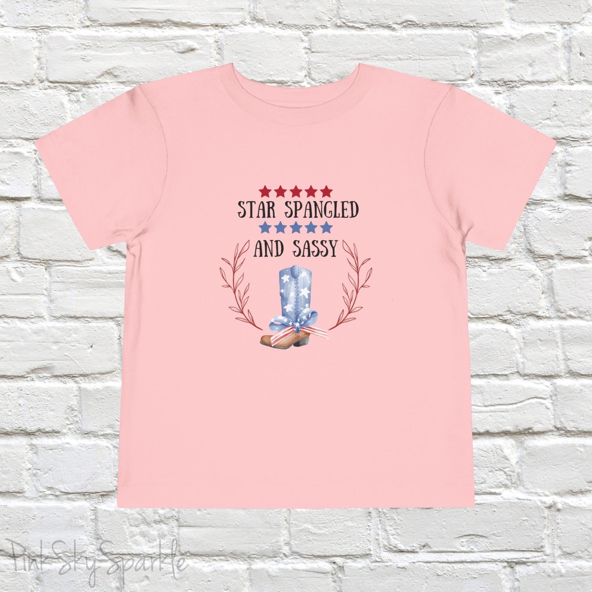Dress your little one in patriotic style with our adorable toddler t-shirt, perfect for the 4th of July! This charming tee features the playful phrase "Star Spangled and Sassy" alongside a cute graphic of a red, white, and blue cowgirl boot adorned with a bow.