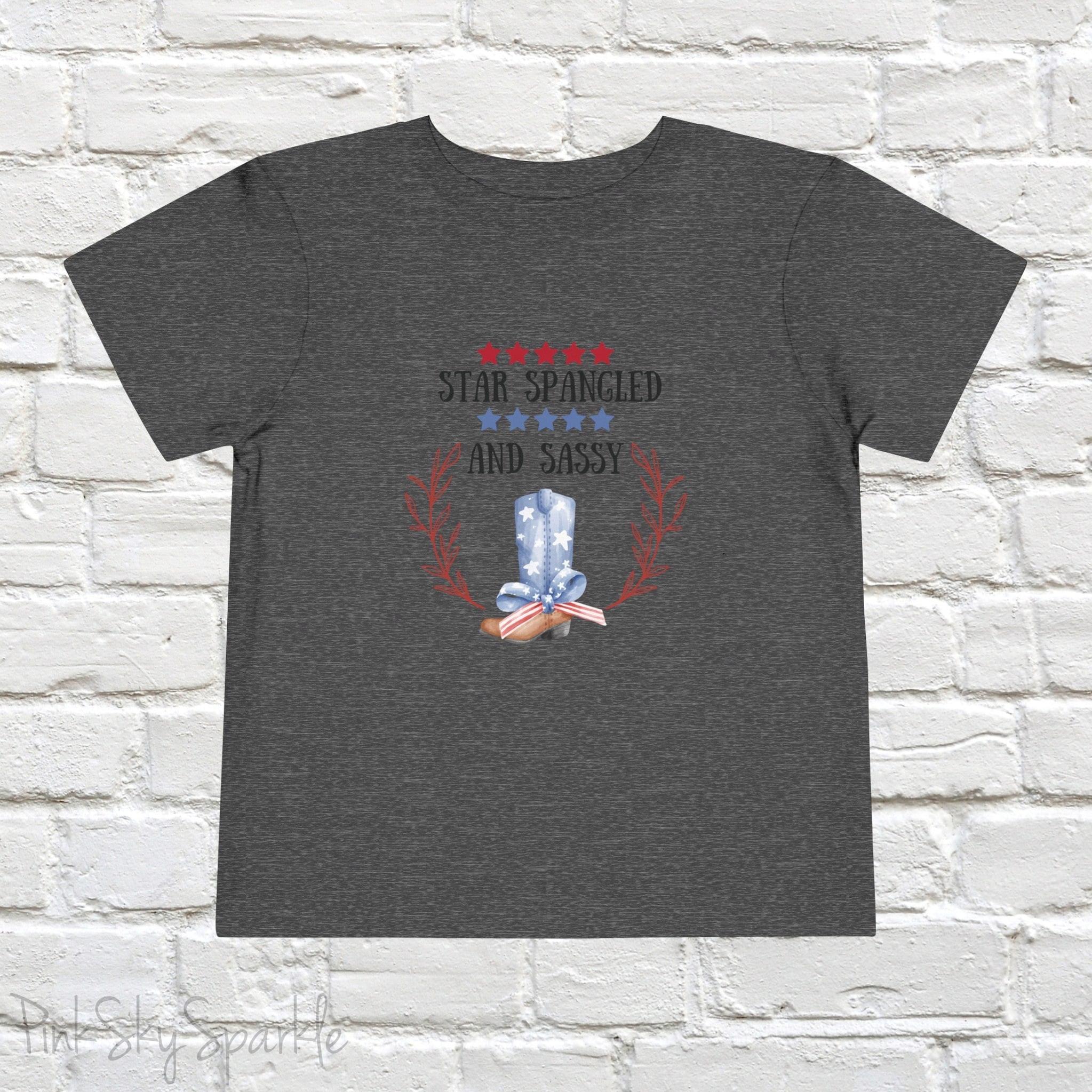 Dress your little one in patriotic style with our adorable toddler t-shirt, perfect for the 4th of July! This charming tee features the playful phrase "Star Spangled and Sassy" alongside a cute graphic of a red, white, and blue cowgirl boot adorned with a bow.