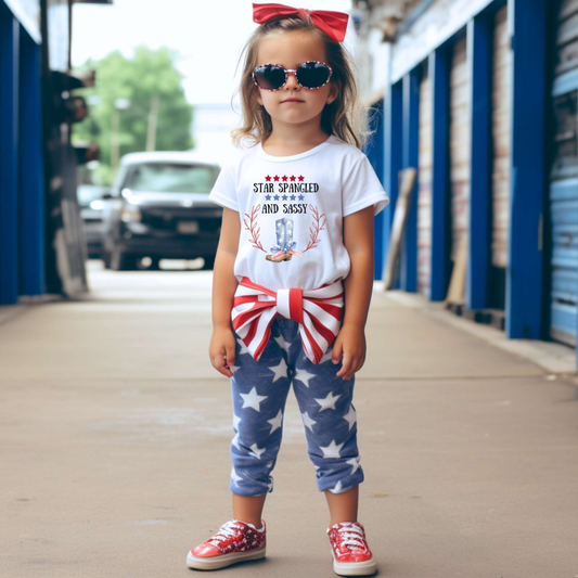 Dress your little one in patriotic style with our adorable toddler t-shirt, perfect for the 4th of July! This charming tee features the playful phrase "Star Spangled and Sassy" alongside a cute graphic of a red, white, and blue cowgirl boot adorned with a bow.